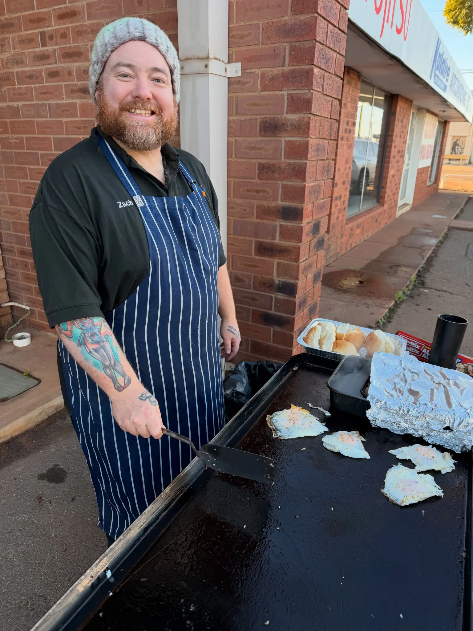 Kalgoorlie IT team member Zach preparing food at the 15th anniversary celebration outside the store.