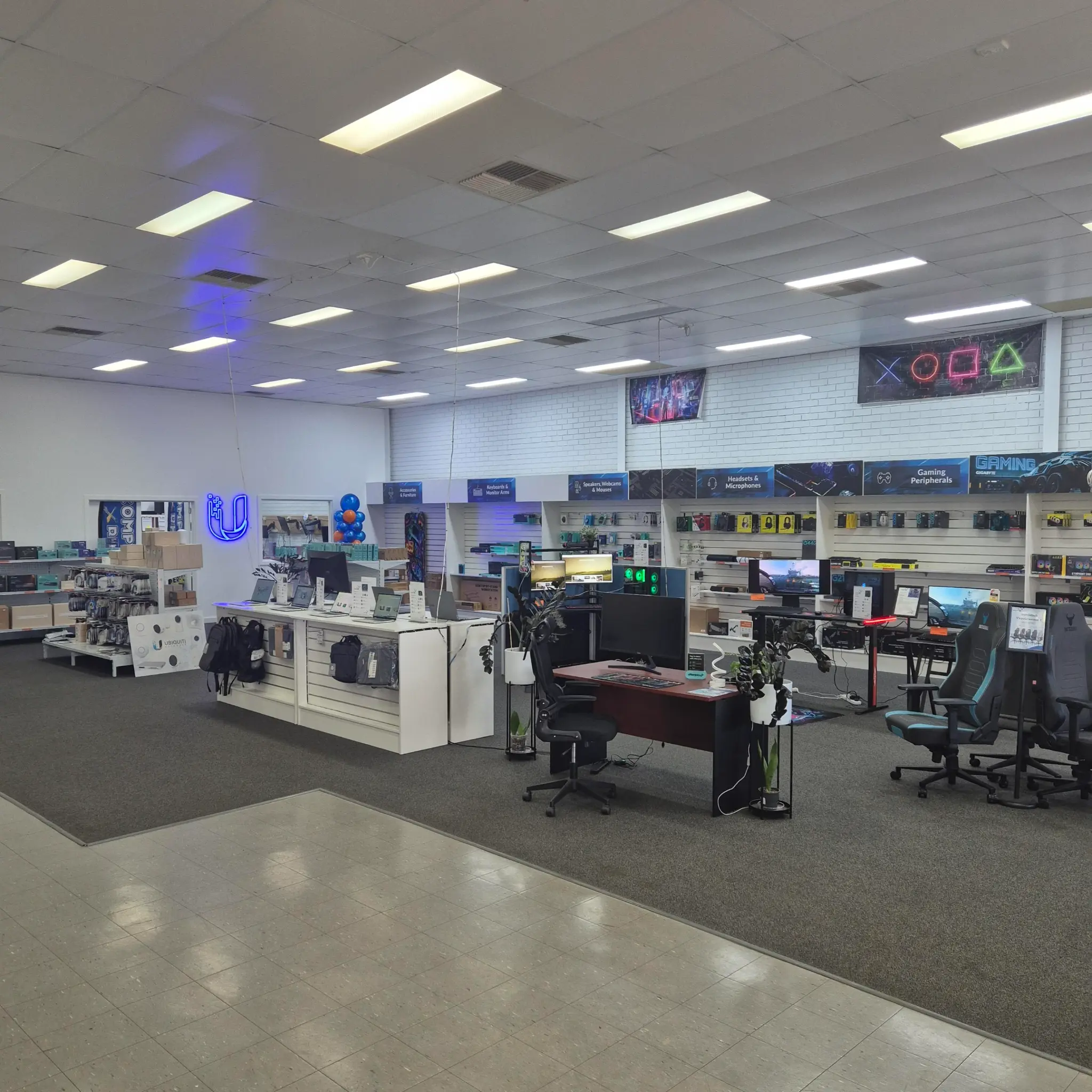 Wide view across Kalgoorlie IT's current retail floor, showing stocked technology displays, counters and gaming equipment.